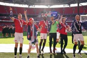 Brad Lyons (far left) celebrates Morecambe’s play-off win over Newport County