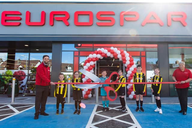 EUROSPAR Doagh store manager Daniel Duncan and community rep Barbara Logan with Doagh Primary School football team players who helped cut the ribbon at the official store opening.