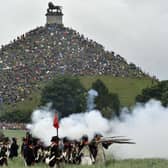 People sit on the Lion's Mound, around the lion monument of the Battle of Waterloo during a re-enactment of the 1815 Battle of Waterloo between the French army led by Napoleon and the Allied armies led by the Duke of Wellington and Field-Marshal Blucher, on June 20, 2010, in Waterloo. On June 18, 1815, Napoleon led his 72,000-strong army into battle with 120,000 mostly British and Prussian soldiers on the gently rolling plateau of Waterloo. For a long time the two forces remained in a bloody embrace, but at the end of the afternoon the French emperor's Great Army was routed at the hands of the Duke of Wellington and Field Marshal Bluecher   . AFP PHOTO / GEORGES GOBET (Photo credit should read GEORGES GOBET/AFP via Getty Images)