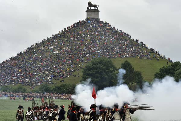 People sit on the Lion's Mound, around the lion monument of the Battle of Waterloo during a re-enactment of the 1815 Battle of Waterloo between the French army led by Napoleon and the Allied armies led by the Duke of Wellington and Field-Marshal Blucher, on June 20, 2010, in Waterloo. On June 18, 1815, Napoleon led his 72,000-strong army into battle with 120,000 mostly British and Prussian soldiers on the gently rolling plateau of Waterloo. For a long time the two forces remained in a bloody embrace, but at the end of the afternoon the French emperor's Great Army was routed at the hands of the Duke of Wellington and Field Marshal Bluecher   . AFP PHOTO / GEORGES GOBET (Photo credit should read GEORGES GOBET/AFP via Getty Images)
