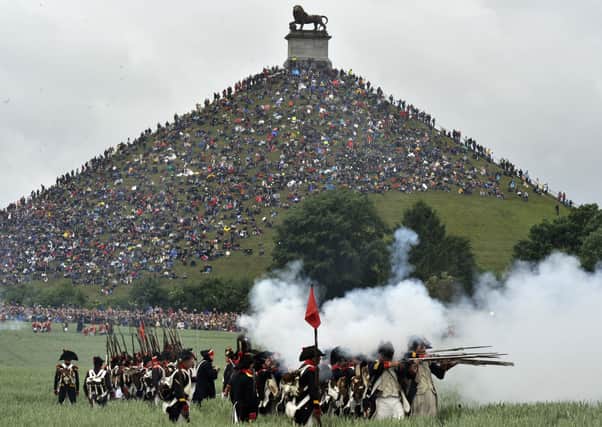 People sit on the Lion's Mound, around the lion monument of the Battle of Waterloo during a re-enactment of the 1815 Battle of Waterloo between the French army led by Napoleon and the Allied armies led by the Duke of Wellington and Field-Marshal Blucher, on June 20, 2010, in Waterloo. On June 18, 1815, Napoleon led his 72,000-strong army into battle with 120,000 mostly British and Prussian soldiers on the gently rolling plateau of Waterloo. For a long time the two forces remained in a bloody embrace, but at the end of the afternoon the French emperor's Great Army was routed at the hands of the Duke of Wellington and Field Marshal Bluecher   . AFP PHOTO / GEORGES GOBET (Photo credit should read GEORGES GOBET/AFP via Getty Images)