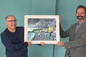 Presenting Rev Ian Carton with a painting of Whitehead seafront by artist Ken Stewart is Martin Clarke, acting chairman of Whitehead Community Association.