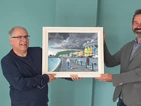 Presenting Rev Ian Carton with a painting of Whitehead seafront by artist Ken Stewart is Martin Clarke, acting chairman of Whitehead Community Association.