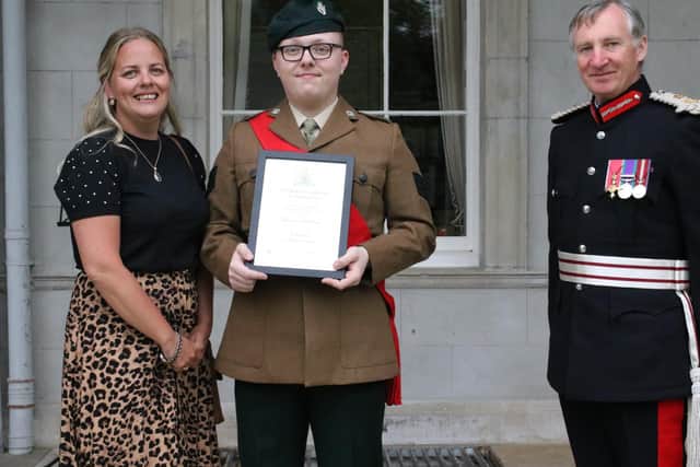 Jake is pictured displaying his award certificate, watched by his mother, Lindsay, and by Mr Robert Scott OBE, Lord ​Lieutenant of County Tyrone.