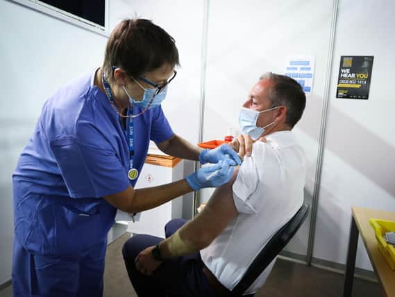 Paul Givan is pictured receiving his vaccine from Rose Scott. Photo by Kelvin Boyes / Press Eye.