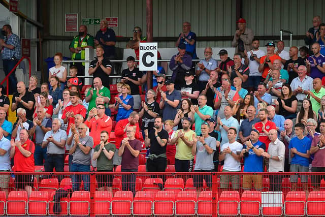 Larne fans salute the players after their win
