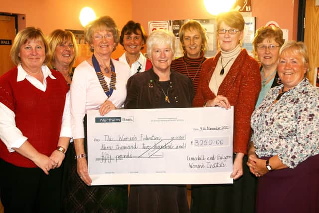 Margaret McMillen (Chairman of the International Subcommittee of the ACWW) receives a cheque for £3250 from Anne Sanford, on behalf of Gracehill and Galgorm Womens' Institute. Included are WI members. BT46-248AC