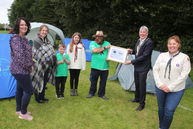 he Mayor of Causeway Coast and Glens Borough Council Councillor Richard Holmes makes a special presentation to Jonny Hoy (Group Scout Leader) alongside Stephanie Meikle (County Commissioner, right), Shauna Tuttey (Chairperson), Robyn Peden, Eve Lynas and Jack Dinsmore to mark 100 years of scouting in Ballymoney