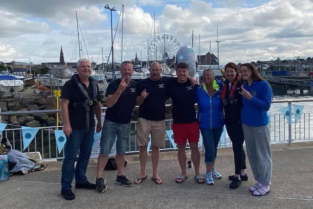 Portadown man Jordan Leckey standing with friends celebrating beating the Guinness World Record by swimming the North Channel from Donaghadee to Scotland  in nine hours, five minutes and 30 seconds.