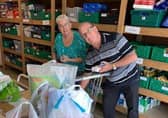 Frank and Esther Mills sorting food in the warehouse.