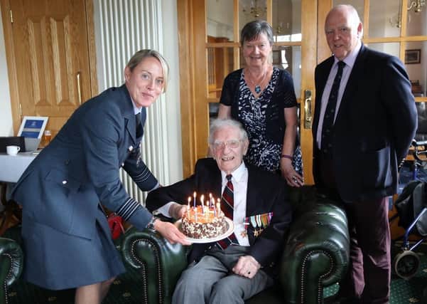 William Nesbitt is presented with his 100th birthday cake from RAF Wing Commander Jacqs Rankin as his daughter Johneen Dempsey and son in law Adrian Dempsey look on