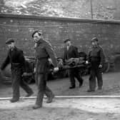 Rescue workers bring a body to the surface at Whitehaven pit where an explosion trapped 15 miners underground in August 1947. Picture: PA