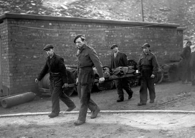 Rescue workers bring a body to the surface at Whitehaven pit where an explosion trapped 15 miners underground in August 1947. Picture: PA
