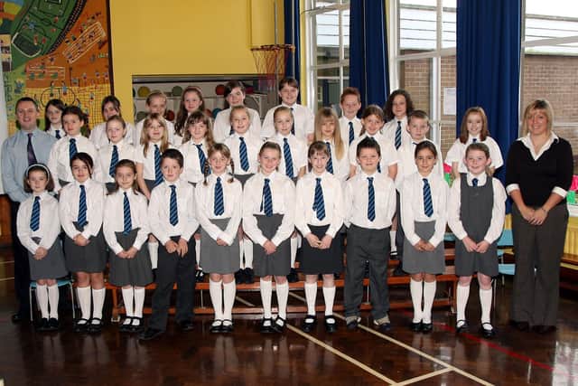 Mr. C. Torrens, Prinaipal of Dunclug Primary School and Miss C. Anderson pictured with members of the school's choir at their Harvest Service. BT43-001JM.