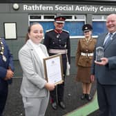 Megan Beattie and George Hill accepting the Queen's Award for Voluntary Service on behalf Rathfern Community Regeneration Group. They are joined by the Lord Lieutenant of County Antrim, Mr David McCorkell, Mayor of Antrim and Newtownabbey, Councillor Billy Webb and Cadet Ciara McKay.