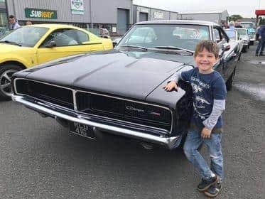 Archie Barr admiring a Dodge Charger.