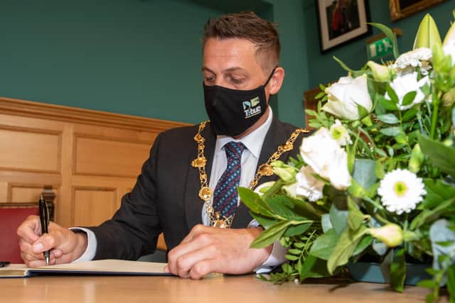 Derry City and Strabane District Council Mayor, Alderman Graham Warke, signs the Book of Condolence for Pat Hume in the Guildhall. Picture Martin McKeown. 03.09.21