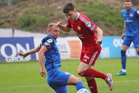 Andrew Mitchell sliding in for Larne to stop Stephen Teggart against Portadown. Pic by Pacemaker.