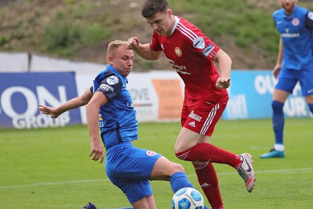 Andrew Mitchell sliding in for Larne to stop Stephen Teggart against Portadown. Pic by Pacemaker.