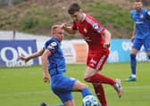 Andrew Mitchell sliding in for Larne to stop Stephen Teggart against Portadown. Pic by Pacemaker.