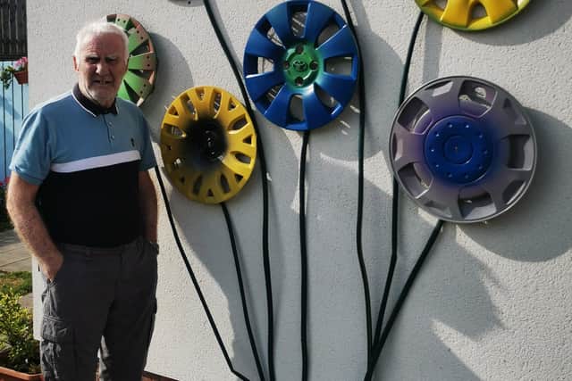 Derek Smith with the wheel trim flowers that he helped to create.