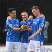 Matthew Shevlin celebrates his brace against Carrick Rangers with Aaron Traynor and Josh Carson