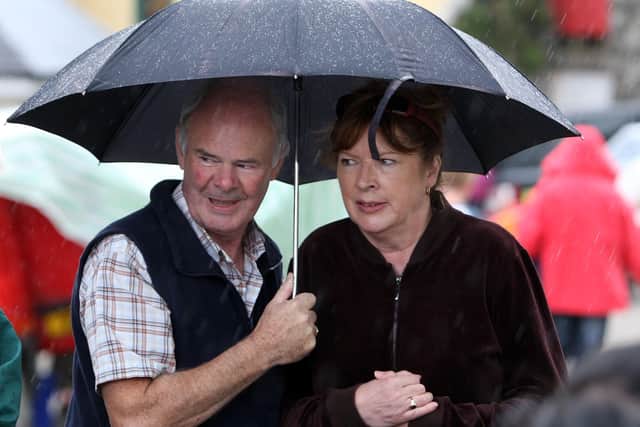 Donal and Liz O’Loan shelter from a shower at the Glenravel Festival Country Fair in August 2009. Picture: John McIlwaine/Ballymena Times/Farming Life archives