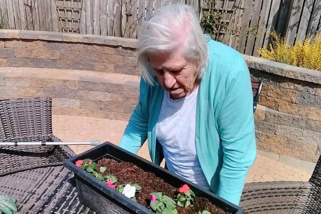Etta enjoying planting flowers in the window boxes for extra decoration.
