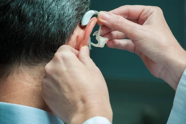 Man having a hearing aid changed (stock image).