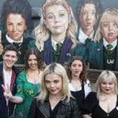 The 'Derry Girls' next to a mural in the city