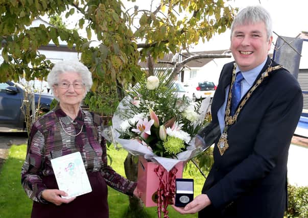 The Mayor of Causeway Coast and Glens Borough Council Councillor Richard Holmes presents a centenary coin to Dorothy Cunningham to mark her 100th birthday on Saturday, September 25