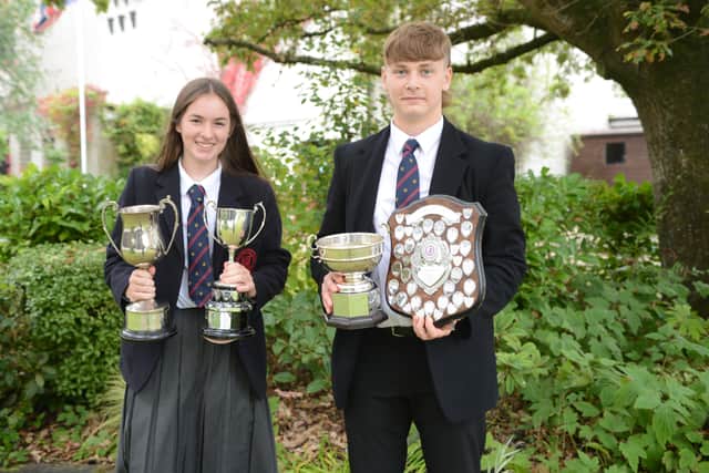Top GCSE students Robyn McCollam 11A star grades and James Spence with 10A star grades with some of their subject trophies.