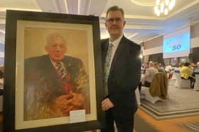 DUP leader Sir Jeffrey Donaldson poses with a painting of the party's founding leader Rev Ian Paisley, by Kenny McKendry, at a Belfast dinner to mark the 50th anniversary of the founding of the party.