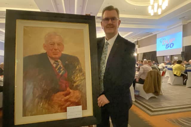 DUP leader Sir Jeffrey Donaldson poses with a painting of the party's founding leader Rev Ian Paisley, by Kenny McKendry, at a Belfast dinner to mark the 50th anniversary of the founding of the party.
