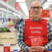 A Tesco volunteer holding a shopping list guide for donations at the launch of the Tesco Food Collection