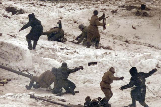Soldiers dressed as Soviet Army and Nazi troops fight with each other at an army drill range in Alabino, outside Moscow during the re-enactment of an episode from the December, 1941, Second World War Battle of Moscow in December 2004. (Photo credit should read Denis Sinyakov/AFP via Getty Images)