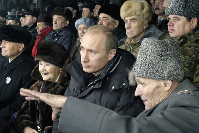 Russian president Vladimir Putin listens to an explanation of a Second World War veteran at an army drill range in Alabino, outside Moscow during re-enactment of an episode from the December, 1941, battle of Moscow in December 2004. (Photo credit should read Alexey Panov/AFP via Getty Images)
