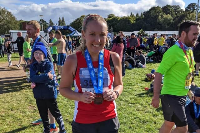 County Antrim Harrier, Louise Holmes, proudly clutches her medal after running in the Belfast Marathon on Sunday.