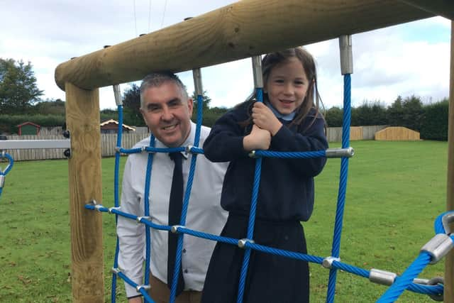 Eva Gordon from Clough Primary School, runner-up in the foundation
category of the 2021 'Dig in! to 10 years of Open Farm Weekend' schools' competition pictured with Principal, Ivor Hutchinson.