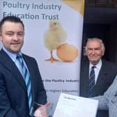 Peter Morgan, Chairman of the Poultry Industry Education Trust, presents the annual Poultry Industry Education Trust award, a Times Atlas of the World and inscribed memento to Wilson McLeister from Portglenone. Looking on is Basil Bayne, a Fellow of Harper Adams University and PIET Trustee.