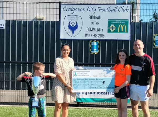 Craigavon man Frank McCabe with his children Michael and Emma handing over a cheque for £3,466 raised through the Angela McCabe Memorial Tournament, a charity soccer tournament held at Craigavon City FC.
