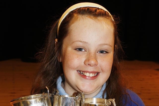 Portstewart Primary School pupil Anna Nicholl holding the cups she won at  Portstewart Music Festival back in June 2010