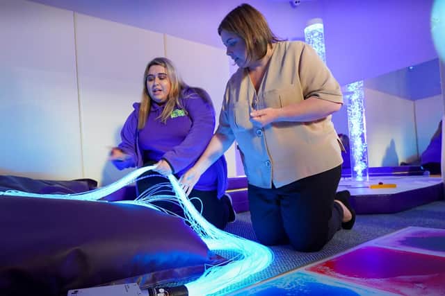Aimee Murphy, Sensory Assistant shows Minister Hargey one of the sensory rooms at High Rise Lisburn