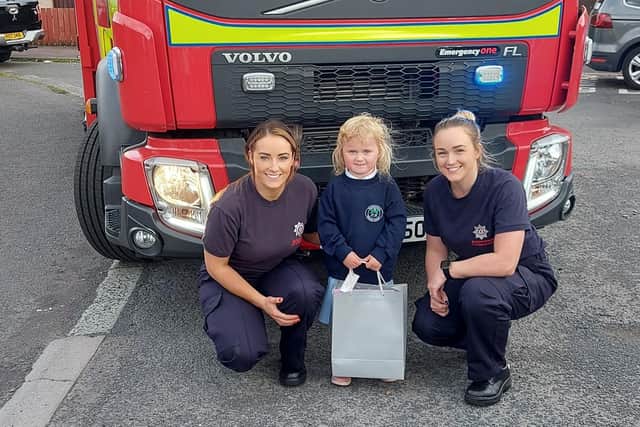 Evelyn pictured with Firefighter Robb and Firefighter Brownlee.