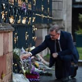 Democratic Ulster Unionist party leader Sir Jeffrey Donaldson looks at flowers lain by members of the public at Hillsborough castle, Her Majesty the Queens place of residence whilst visiting the province following the news that she had passed away on September 8, 2022. (Photo by Charles McQuillan/Getty Images)