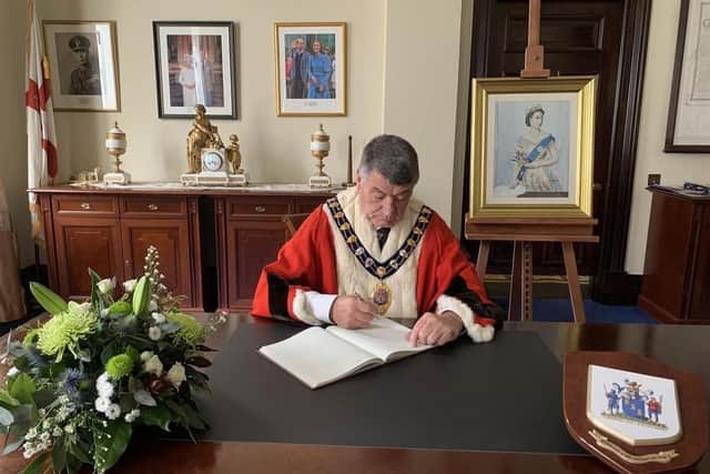 The Mayor of Mid and East Antrim, Alderman Noel Williams, signs the book of condolence.