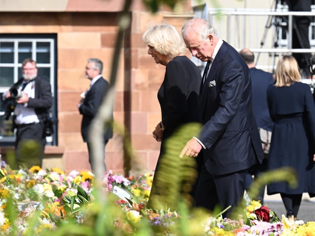 King Charles III and the Queen Consort look at floral tributes as they arrive at Hillsborough Castle, Co Down. Picture date: Tuesday September 13, 2022.