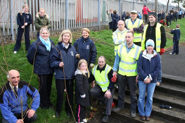 Members of Harryville Partnership Initiative, who helped pupils from Harryville Primary School to plant willow trees along the school’s perimeter fence, are seen here with Frank Jackson (left) of Ballymena Ecos Centre school staff and pupils. BT46-115JC