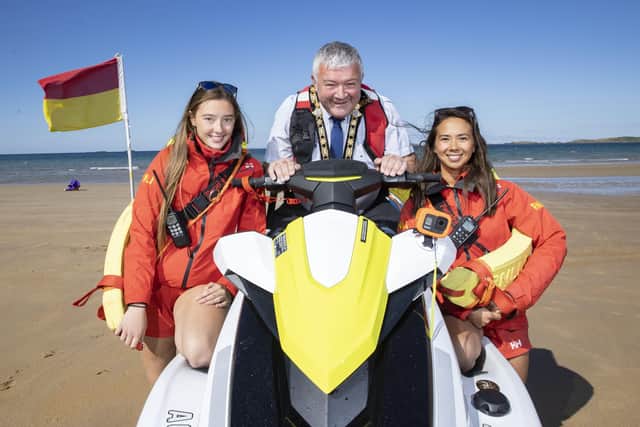 The Mayor of Causeway Coast and Glens Borough Council, Councillor Ivor Wallace, pictured at East Strand in Portrush with RNLI lifeguards Ellen Knox and Annie Jagoe
