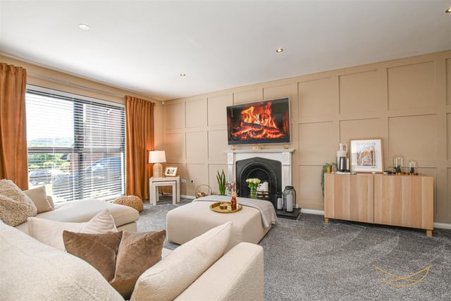 Living room with open fire and feature wood panelling. Recessed spotlights.